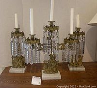 Full set of three candelabras on a wood surface showing overall appearance and scale.