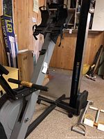 Full side view of the rowing machine showing frame, footrests and flywheel housing