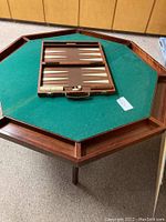 Octagonal poker table shown with the green felt game surface and backgammon set placed on top.