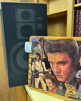 Pair of Technics SB-2660 speakers alongside the framed Elvis Presley collage art featuring his images in various scenes and styles.
