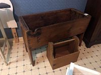 Front angle view of large antique pine dough box with smaller carry handle box in front.