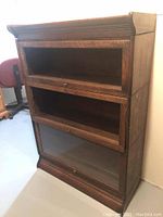 Front view of three-tier oak barrister bookcase showing empty compartments and missing glass doors