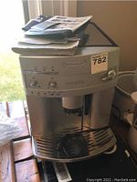 Front view of the DeLonghi Magnifica machine showing control panel and steam wand