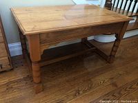 Full side view of vintage pine table showing leg design and stretcher support.