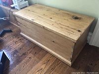 Front view of the vintage pine trunk highlighting the wood grain, dovetail joints, and overall shape.