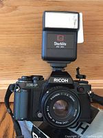 Front view of Ricoh XR-P camera with 50mm lens and Starblitz flash mounted.