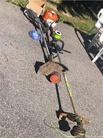 Overview of two trimmer assemblies and line spool on pavement