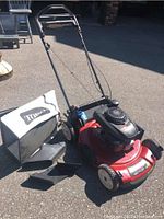Front-left view of mower showing deck, handlebars, grass bag and chute