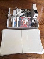 Full lot of Nintendo Wii console, balance board, games, controllers, and cables in a box.