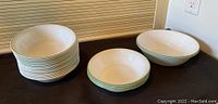 View of stacked cereal bowls and two large serving bowls, showing their size and design.