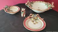 All four Fitz & Floyd Christmas-themed ceramic serving pieces displayed on black backdrop.