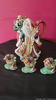 Full view of the Santa Claus tea pot with three matching stocking shakers in front.