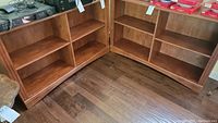 Front view of the two wooden bookcases placed side by side, showing three shelves each.