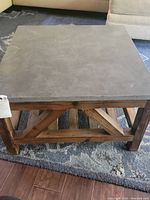 Top view showing square gray slate top of coffee table with scratches and natural texture.