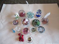 Photo showing entire collection on white background including various paperweights, glass cherries, miniature bowls and abstract glass pieces.