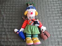 Front view of the Big Knit doll fully dressed with accessories including umbrella, bag, and penguin figure.