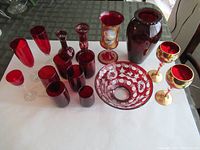 Full view of all red glass drinkware items arranged on a white surface.