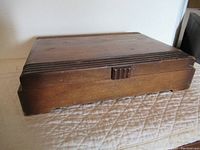 Closed wooden box for the cutlery set showing a plain design and wear.