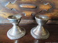 Pair of vintage sterling silver weighted candle holders, front view showing shape and decorative beaded base edge.