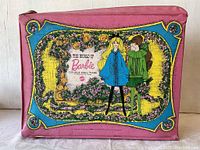 Front view of pink soft-sided Barbie double doll case with colorful printed graphic of two dolls and branding