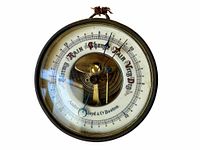 Front view of the antique round barometer showing dial with weather indications and brand name Andrew J. Lloyd & Co Boston.