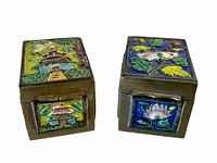 Pair of antique cloisonné stamp boxes shown from a front angled view highlighting designs on top and front sides.