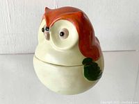Side angle view of the porcelain owl sugar dish showing the hand-painted brownish-orange head and green wing detail.