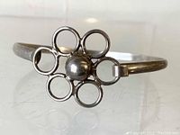 Front view of the silver Taxco daisy bracelet showing the flower motif with six open circles as petals and a round bead at the center, on a plain band.