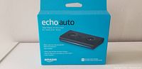 Box of Amazon Echo Auto device, showing front of blue packaging with product image and branding.