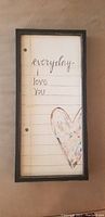 Photo of a framed decorative panel with handwritten message and heart artwork.