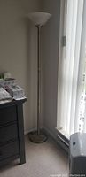 71-inch tall floor lamp standing near corner with broken base, silver metal pole, and white frosted glass top.