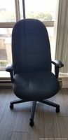 Front view of black fabric office chair showing seat, backrest, and armrests.