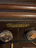 Close-up of the front panel showing two tuning knobs with worn paint and the label 'Dictator Hudson's Bay Company'.