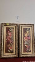 Pair of framed floral prints side by side on a wall showing full frames and flower compositions