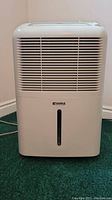 Front view of white Kenmore dehumidifier with air intake grille and water level indicator.