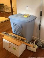 Full lot view showing all items together: laundry hamper, bread box, spirit level, handheld vacuum, and a duster beside them.