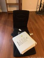 Homedics Destress massage pad laid out on wooden floor with controller and accompanying Thermotex box placed on top.