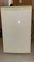 Front view of the white Danby mini fridge with a smooth door and top handle.