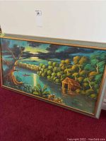 Full view of the framed acrylic landscape painting showing the river, trees, small hut, boat and dramatic sky.