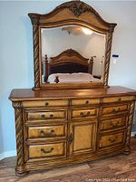 Front view of dresser with attached mirror showing drawer layout and center cabinet