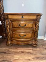 Front view of entire nightstand showing overall design, three drawers, handles