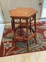 Side view of the hexagonal two-level wooden side table showing decorative sides and lattice lower shelf.
