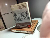 Two hardcover history books related to Indian Wars and American Indian culture on a white table.