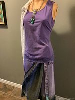 Photo of mannequin wearing purple sleeveless blouse and reversible silk wrap skirt with lace detail; necklace with aqua beads visible