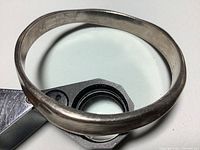 Oval-shaped sterling silver bracelet shown on white background highlighting the hammered texture and overall shape.