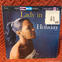 Front cover of 'Lady in Satin' Billie Holiday vinyl record, showing grading label NM 68 and Columbia records branding.