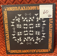 Front cover of Roberta Flack & Donny Hathaway vinyl record with symmetrical white handprints and orange text on black background. Sleeve shows edge wear.