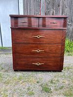 Front view of the mahogany tallboy dresser, showing four drawers with brass handles and wood finish.