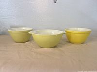 Front view of three yellow Pyrex bowls, one with double pouring spouts