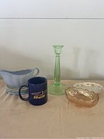 Full lot photo showing uranium glass candlestick, carnival dish, lupin gravy dish, plates, and Bell mug.